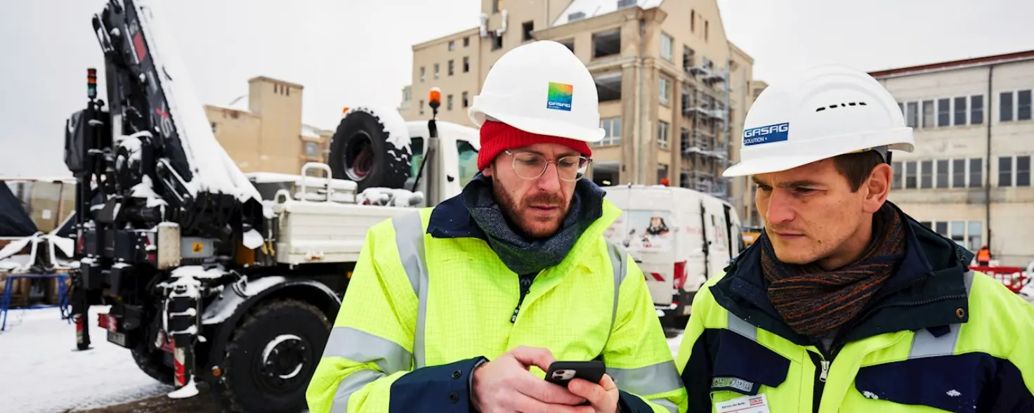 Zwei Arbeiter schauen auf einem Smartphone