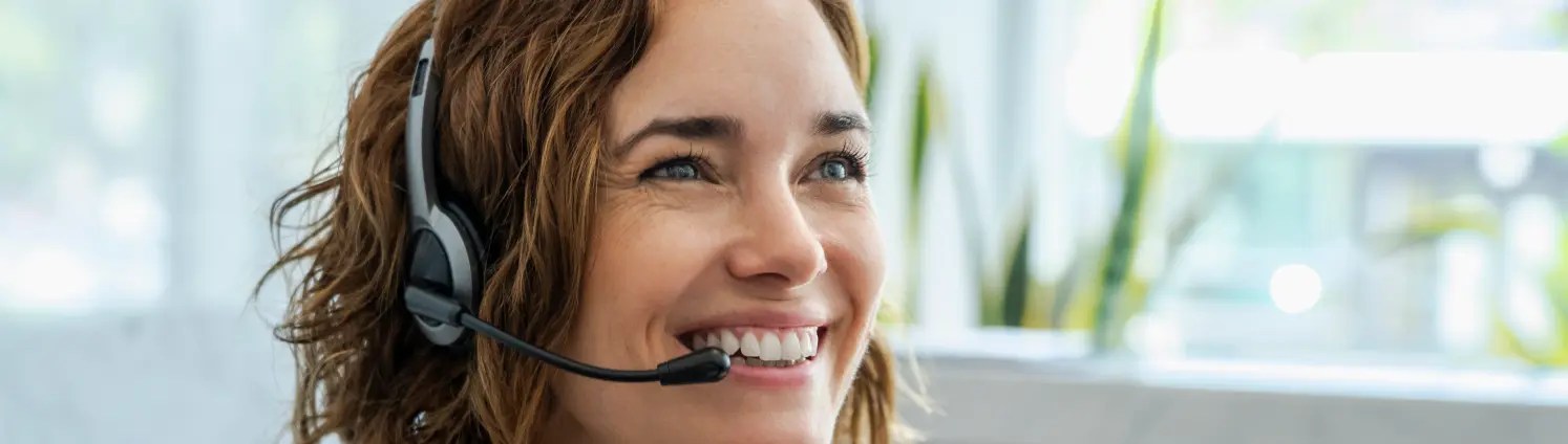 Frau mit Kopfhörern im Kundenservice