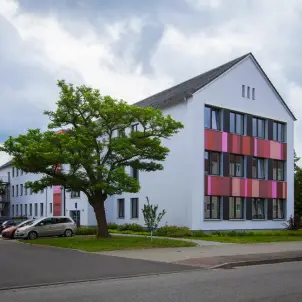 Haus der Bildung und Technologie in Schwedt mit moderner Architektur, farbig gestalteter Fassade und begrüntem Vorplatz.