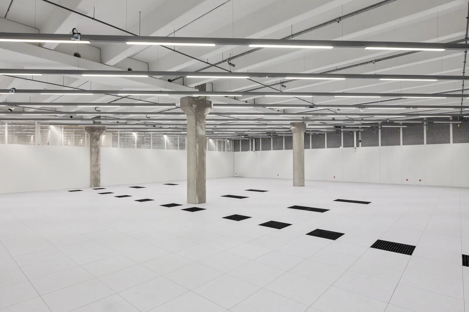 Leerer Serverraum im Rechenzentrum Marienpark mit Doppelboden, technischen Installationen und vorbereiteten Stellflächen für IT-Infrastruktur. Bild mit KI erstellt.