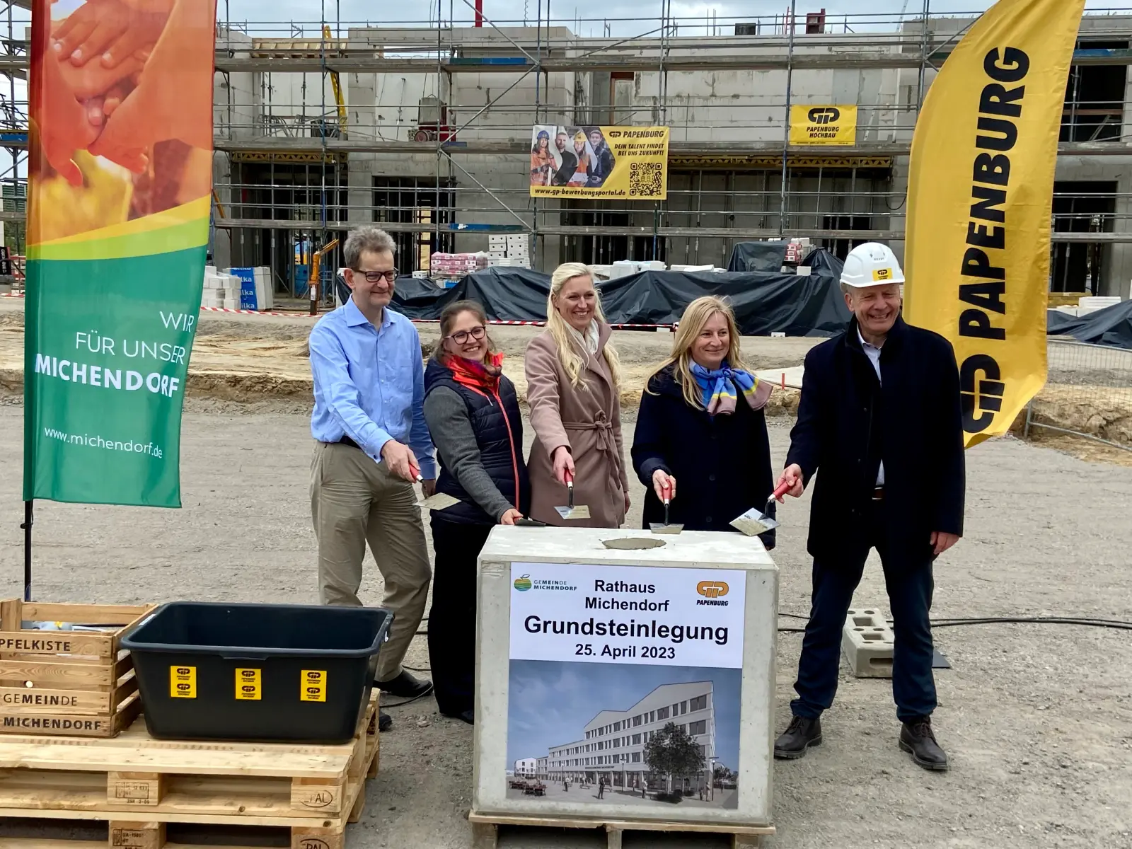 Grundsteinlegung Michendorfer Rathaus am 25. April 2023. Fünf Projektbeteiligte mit Maurerkellen.