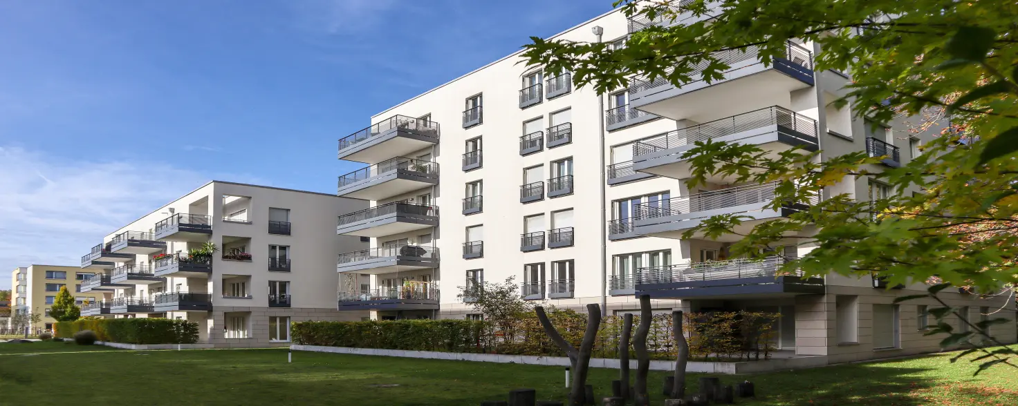 Moderne, weiß gestrichene Mehrfamilienhäuser mit Balkonen in der Front-Ansicht